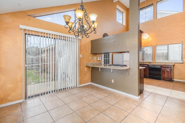 kitchen featuring dishwasher, lofted ceiling with beams, white fridge, and light tile patterned floors