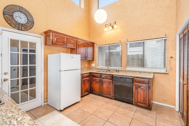 kitchen featuring sink, light tile patterned floors, dishwasher, and white fridge