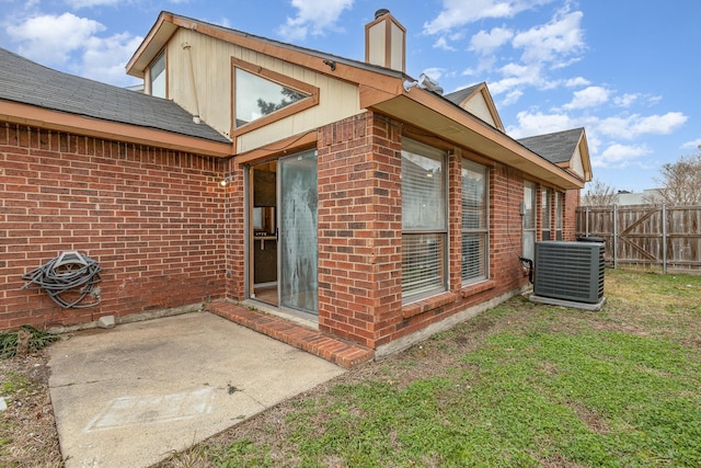 view of side of home featuring central AC unit, a lawn, and a patio