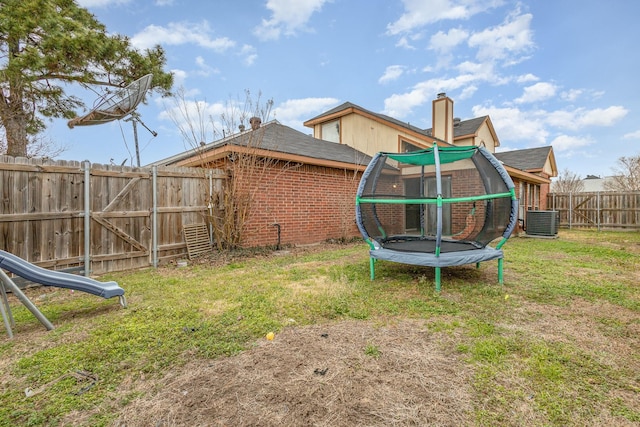 view of yard featuring central AC and a trampoline