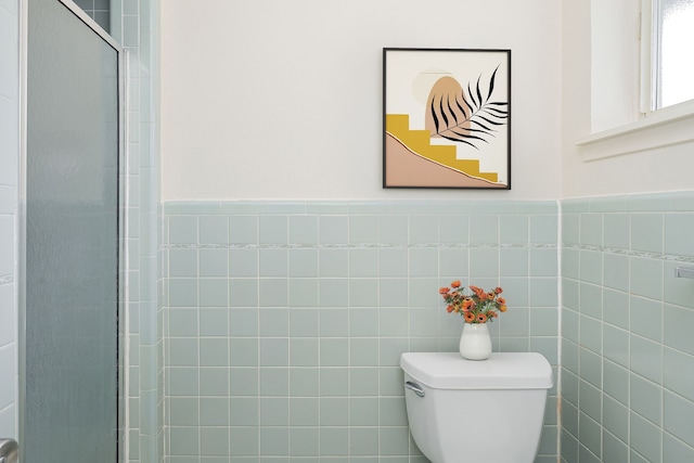 bathroom with a shower with shower door and toilet