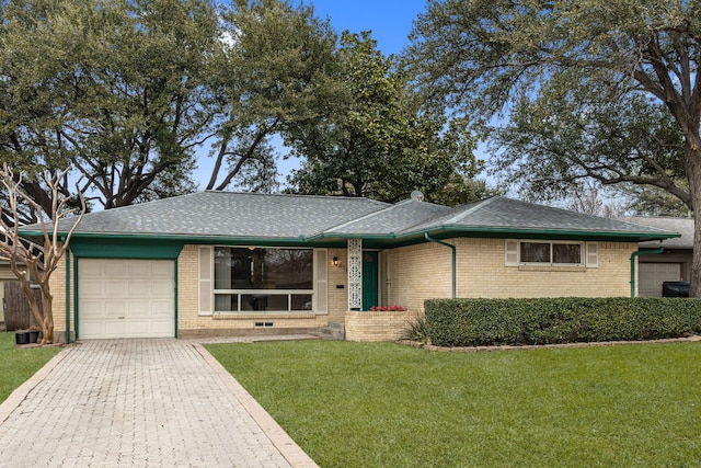 ranch-style house featuring a garage and a front lawn