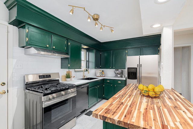 kitchen with wooden counters, green cabinetry, sink, backsplash, and stainless steel appliances