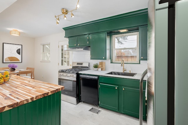 kitchen with black dishwasher, butcher block counters, stainless steel gas stove, sink, and green cabinetry