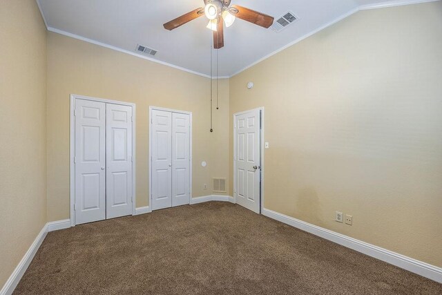 unfurnished bedroom with multiple closets, ornamental molding, carpet floors, and ceiling fan