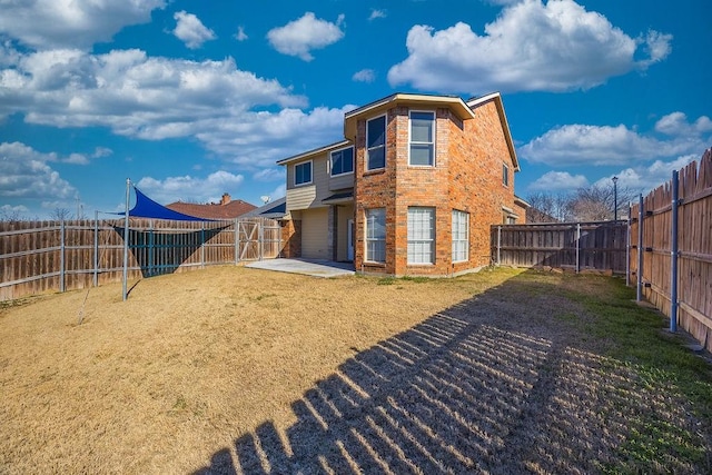 back of house with a patio and a yard