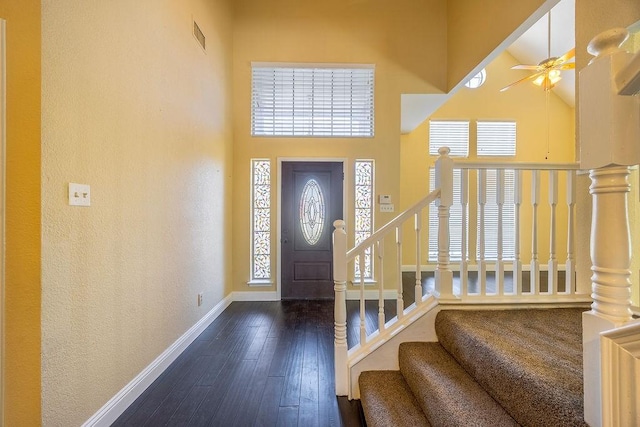 entryway featuring a high ceiling, dark wood-type flooring, and ceiling fan