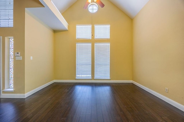 empty room featuring ceiling fan, high vaulted ceiling, and dark hardwood / wood-style flooring