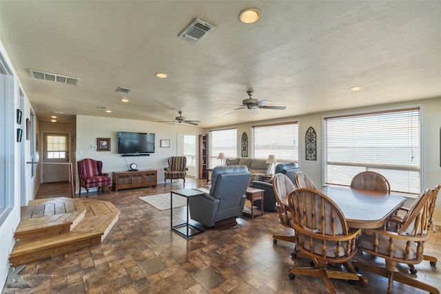 dining area featuring a healthy amount of sunlight, a textured ceiling, and visible vents