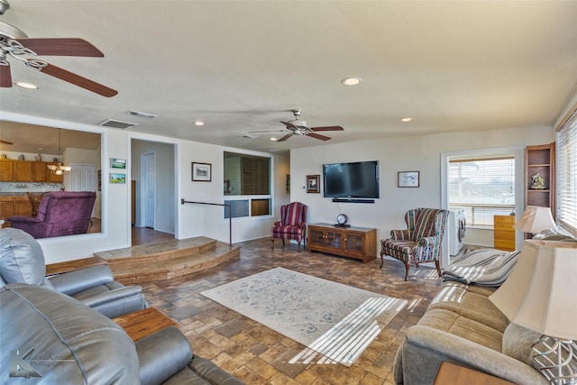 living area with stone finish floor, visible vents, recessed lighting, and ceiling fan