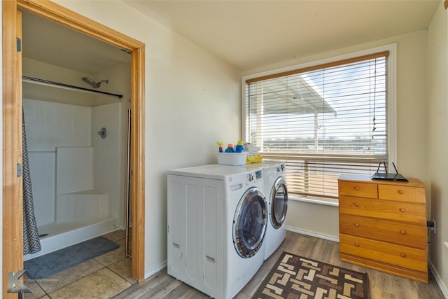 clothes washing area featuring light wood finished floors, independent washer and dryer, and laundry area