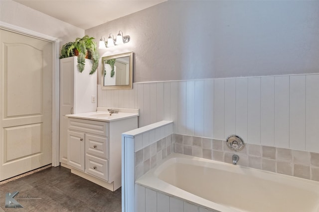 full bathroom featuring a bath, a wainscoted wall, and vanity