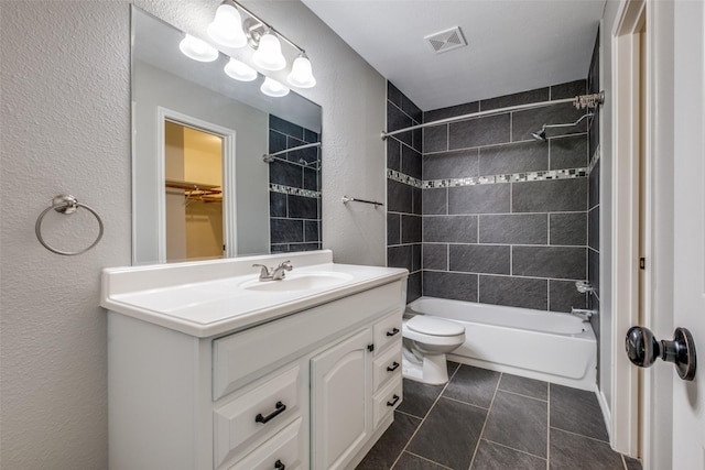 full bathroom featuring toilet, tiled shower / bath, tile patterned floors, and vanity