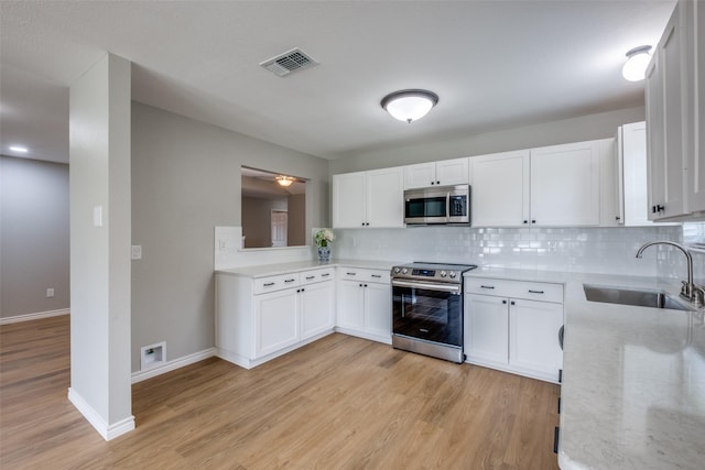 kitchen with sink, white cabinetry, appliances with stainless steel finishes, and tasteful backsplash