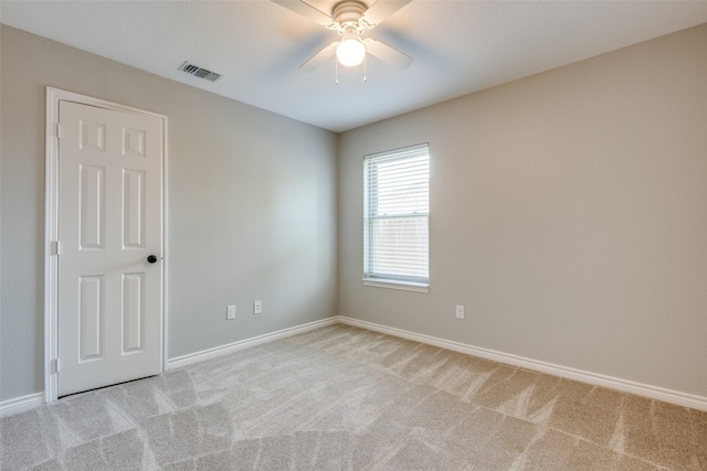 carpeted spare room with ceiling fan