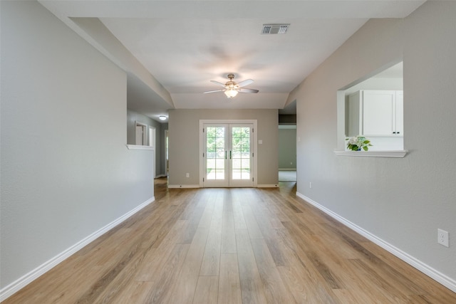 unfurnished living room featuring ceiling fan, french doors, and light wood-type flooring