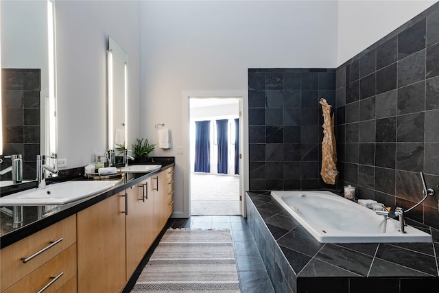 bathroom featuring vanity, tiled bath, and tile patterned flooring