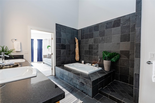 bathroom featuring tiled bath, sink, and tile patterned flooring