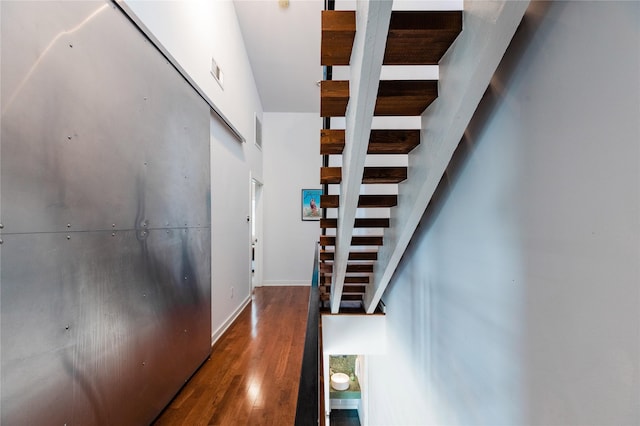 stairs with a high ceiling and hardwood / wood-style floors