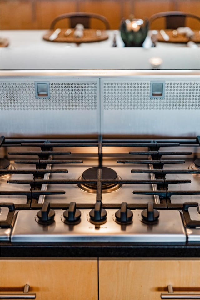 interior details with light brown cabinetry and cooktop