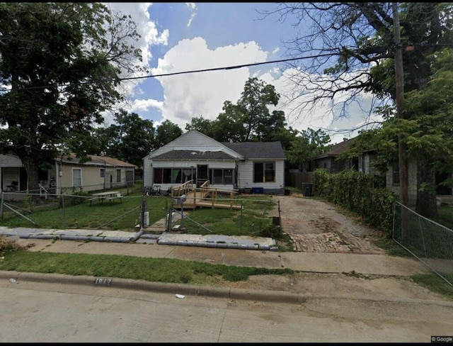 bungalow featuring a front lawn and a fenced front yard