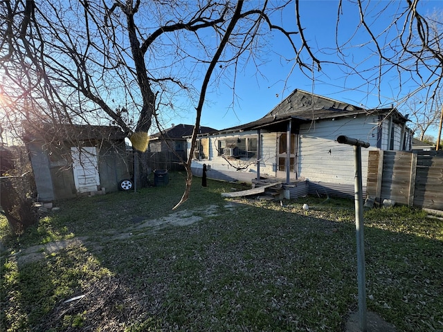 back of house featuring fence and a lawn