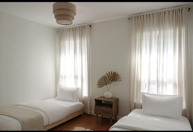 bedroom featuring multiple windows and dark hardwood / wood-style flooring