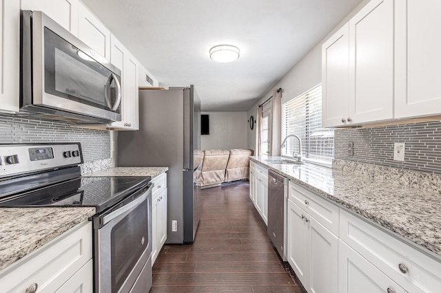 7221 Chinaberry Rd, Dallas, TX 75249 - kitchen with stainless steel appliances, a sink, dark wood-style flooring, tasteful backsplash, and white cabinetry