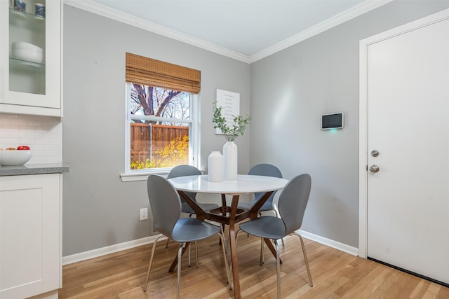 dining area featuring ornamental molding and light wood-type flooring