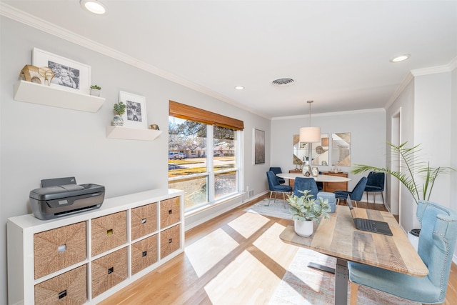 dining area with light hardwood / wood-style flooring and crown molding