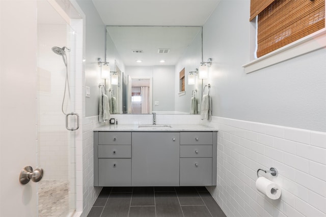 bathroom with vanity, tile walls, an enclosed shower, and tile patterned flooring