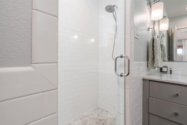 bathroom with a shower with shower door and vanity