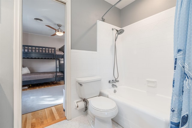 bathroom with shower / tub combo, tile walls, hardwood / wood-style flooring, toilet, and ceiling fan