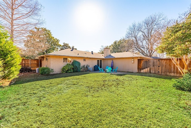 back of house featuring central air condition unit, a patio area, and a lawn