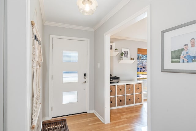 entrance foyer featuring ornamental molding and light wood-type flooring