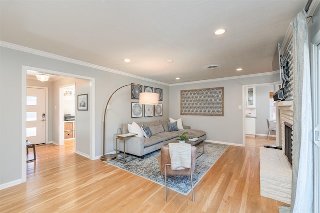 living room featuring a brick fireplace, wood-type flooring, and ornamental molding