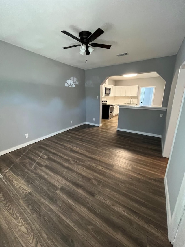 unfurnished living room with dark wood-type flooring and ceiling fan