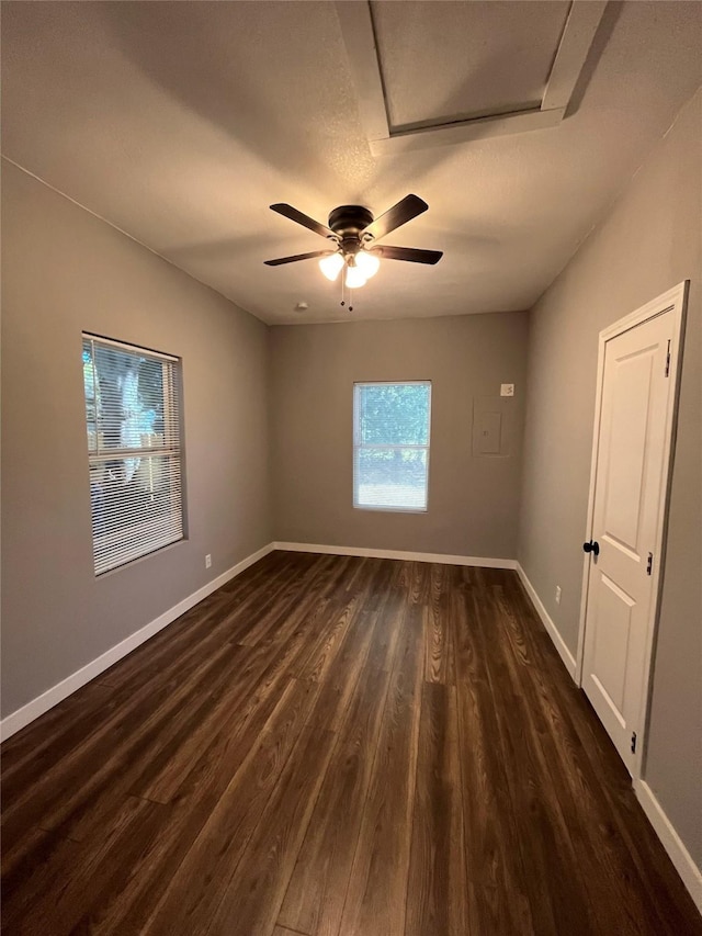 empty room with dark wood-type flooring and ceiling fan