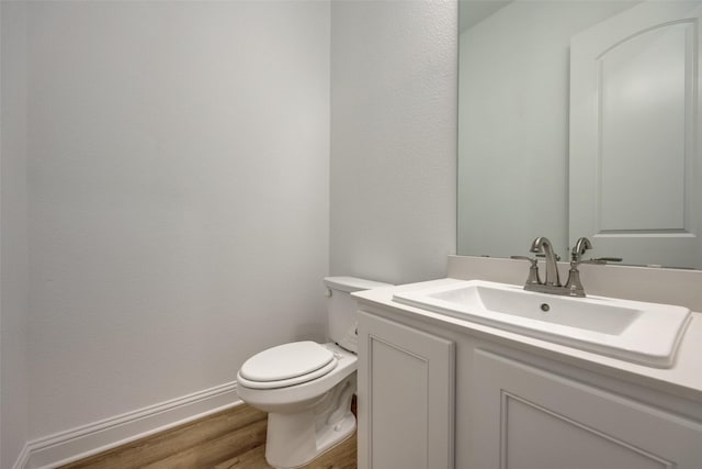 bathroom featuring vanity, hardwood / wood-style flooring, and toilet