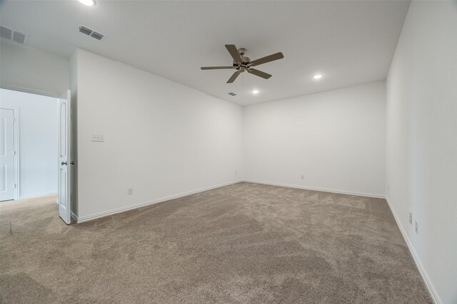 carpeted spare room with ceiling fan