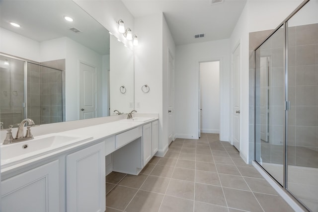 bathroom with vanity, a shower with door, and tile patterned flooring