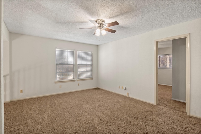 carpeted empty room featuring ceiling fan and a textured ceiling