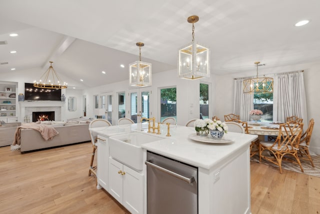 kitchen with decorative light fixtures, light hardwood / wood-style flooring, a center island with sink, dishwasher, and white cabinets