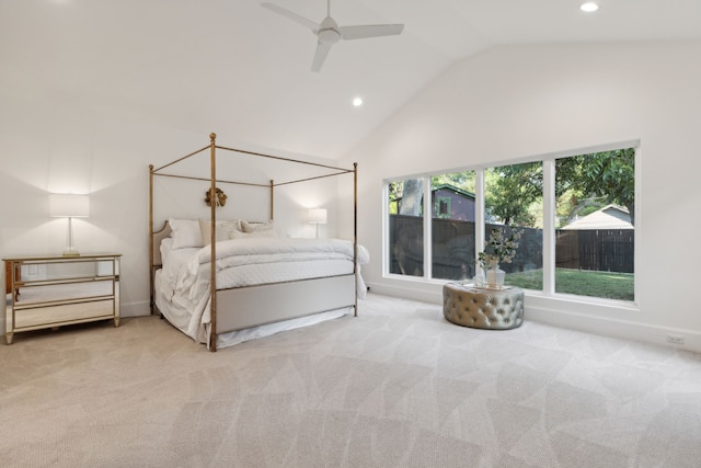 carpeted bedroom with ceiling fan and high vaulted ceiling