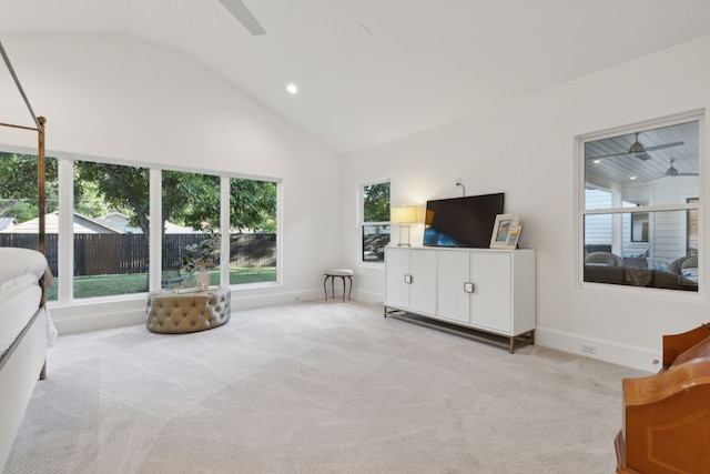 living room with light colored carpet, a healthy amount of sunlight, and high vaulted ceiling