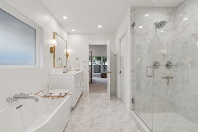 bathroom with vanity and shower with separate bathtub