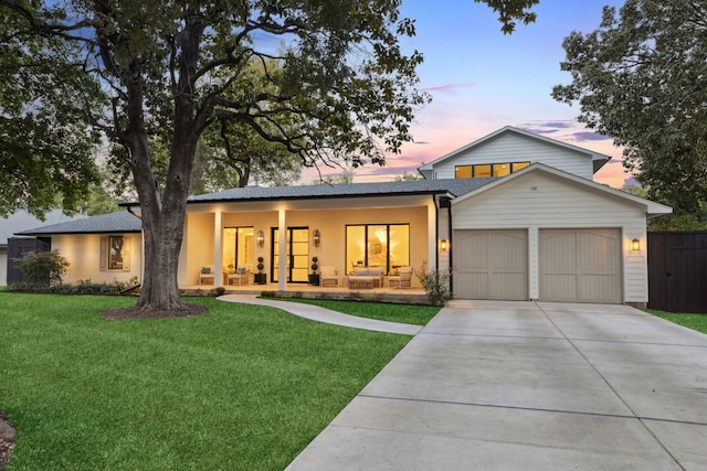 view of front of house featuring a porch, a garage, and a lawn