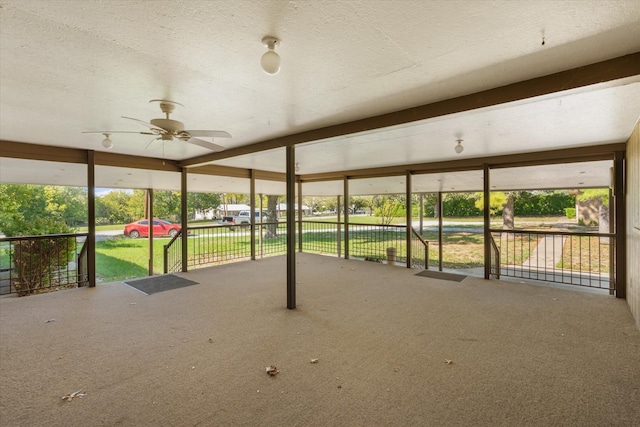 unfurnished sunroom with ceiling fan and a wealth of natural light