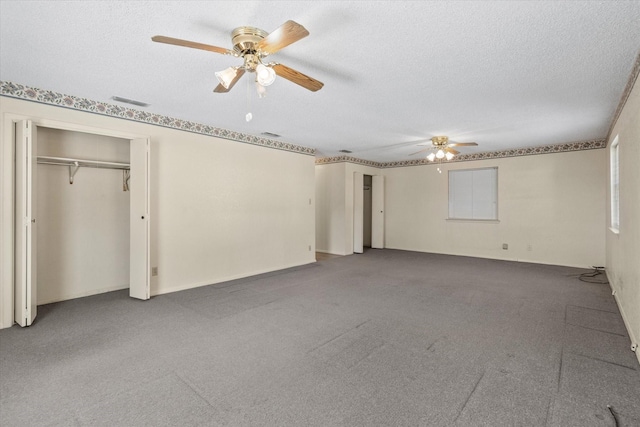 unfurnished bedroom with a closet, ceiling fan, carpet floors, and a textured ceiling