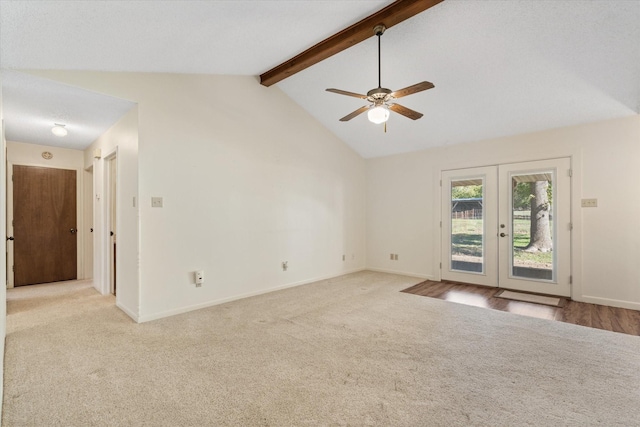 carpeted empty room featuring french doors, ceiling fan, and vaulted ceiling with beams